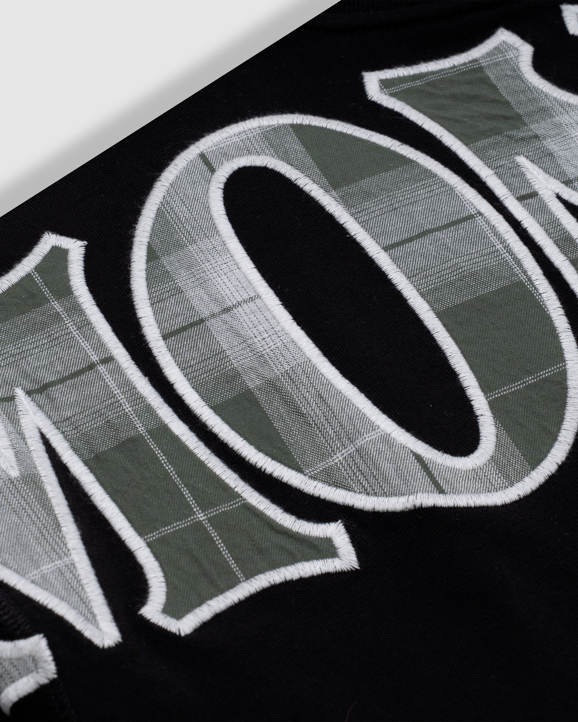 Camiseta negra oversized con doble manga en cuadros verdes y blancos con un bordado trasero en la parte superior | Camisetas MONOIC